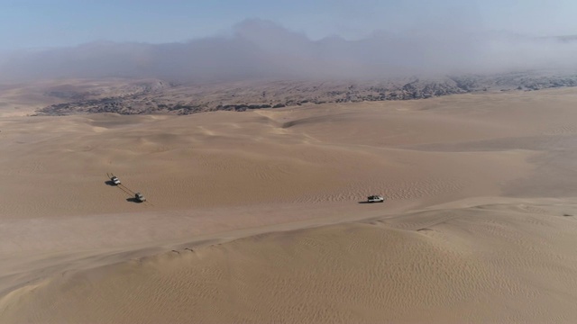 4K空中缩放的视野，4x4车辆沿着美丽的沙丘骨架海岸，纳米比亚沙漠，纳米比亚视频素材