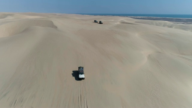 4K空中缩放的视野，4x4车辆沿着美丽的沙丘骨架海岸，纳米比亚沙漠，纳米比亚视频素材