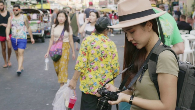 亚洲旅行者/游客在泰国曼谷Khao San路步行街散步和旅游拍照视频素材