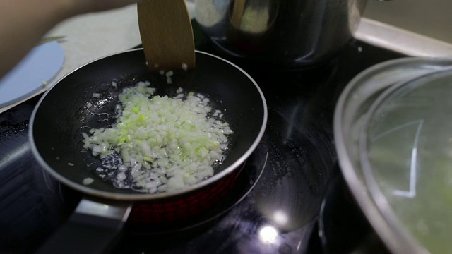 用滚烫的油炸碎洋葱。煎锅的特写，煮洋葱视频素材