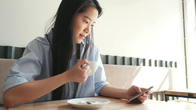 年轻女子在浏览她的智能手机。视频素材