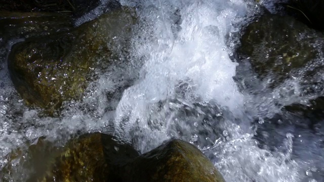 慢镜头水在小河中流动和溅起水花视频素材