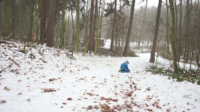 男孩骑着雪橇下山视频素材