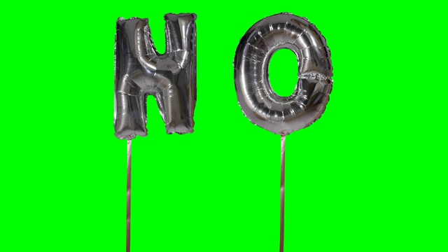 绿色屏幕上漂浮着银色氦气气球上的字母视频下载