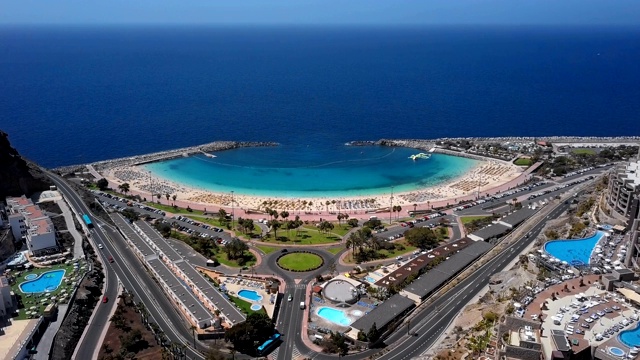 夏天飞行靠近阳光明媚的阿莫多雷斯海滩(Playa de Amadores)和绿松石海，大加那利群岛，加那利群岛，西班牙视频素材