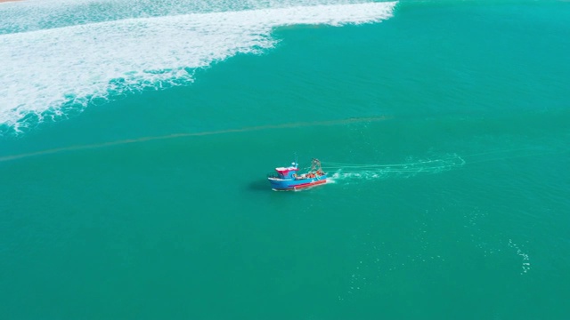 在海岸附近的海浪上漂浮的渔船视频素材