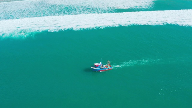 在海岸附近的海浪上漂浮的渔船视频素材