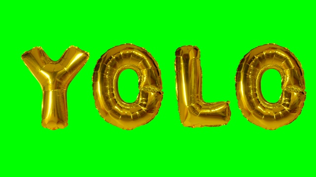 绿色屏幕上漂浮着氦气金气球上的字母YOLO视频下载
