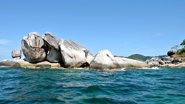 航行在热带海洋与岩石堆积的唇岛视频素材