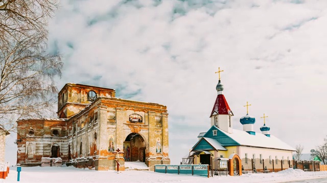 白俄罗斯戈麦尔地区多布斯区雷诺村。The Old Ruined Orthodox Church Of The St. Nicholas Near New Church In Winter Day.圣尼古拉斯东正教在冬天的新教堂附近。历史文化遗产视频素材