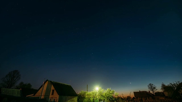 夜晚，村庄房屋上的星空背景。自然发光的星星夜景视频素材