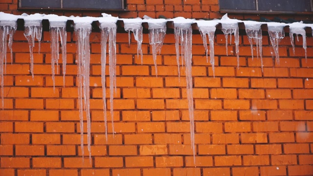 屋顶上挂着冰柱，正在下雪视频素材