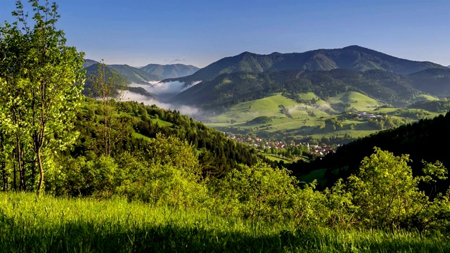 日出在绿色的自然景观与雾云在山谷在春天的早晨时间流逝视频素材