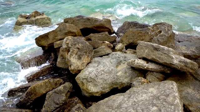 海浪拍打着多石的海滩，形成水花视频素材