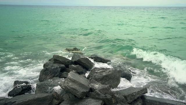 自然背景。汹涌的海浪拍打着海岸的岩石，慢镜头视频素材