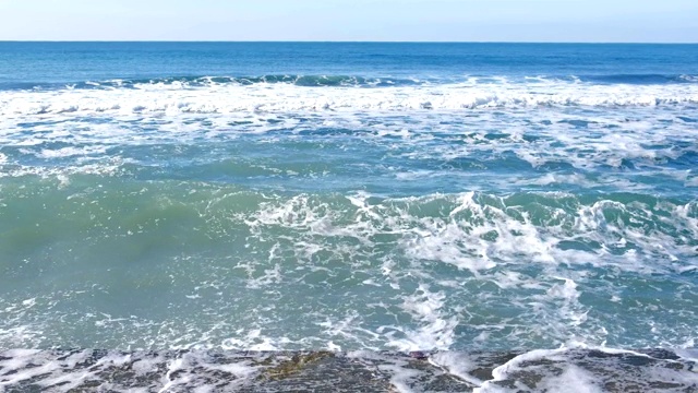 汹涌的海浪拍打在防波堤上的水花。视频素材