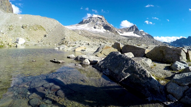 维托里奥·埃马努埃莱二世避难所小屋附近的山湖和山脉的全景，探险到意大利阿尔卑斯山的大帕拉迪索山顶视频素材