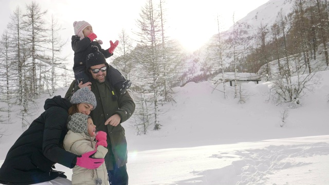 冬天的一天，山上的一家人在雪地和大自然中散步。视频素材