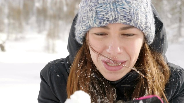 在冬天的一天，一个美丽的女人在山上玩雪，呼吸着清新的空气，沉浸在大自然中。视频素材