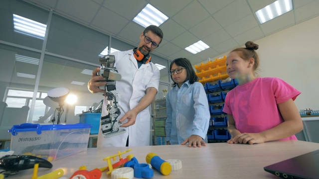 小学机器人技术。学校老师与聪明的学生一起学习机器人技术。视频素材