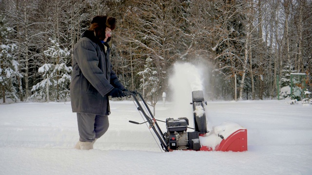 冬天，在森林里，人们用扫雪机清理积雪视频素材