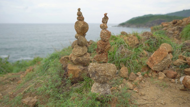 沙土上矗立着两座金字塔状的石头。凯恩在海面上的山顶上视频素材