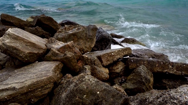 海浪拍打着多石的海滩，形成水花视频素材