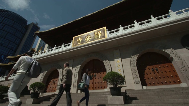 在中国上海市中心的静安寺前，人们以慢动作行走的低角度视角视频素材