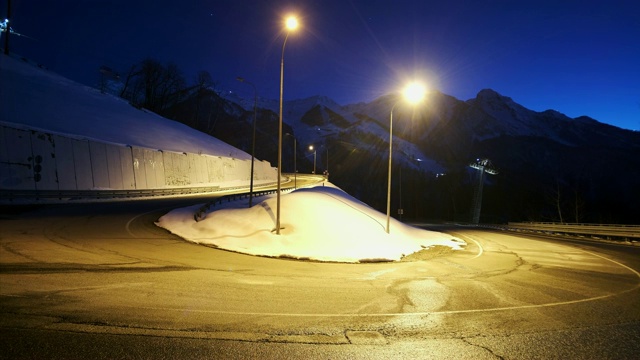 时间流逝在道路上，在月光下的夜晚，以山为背景。罗莎Khutor,索契。晚上交通汽车视频素材