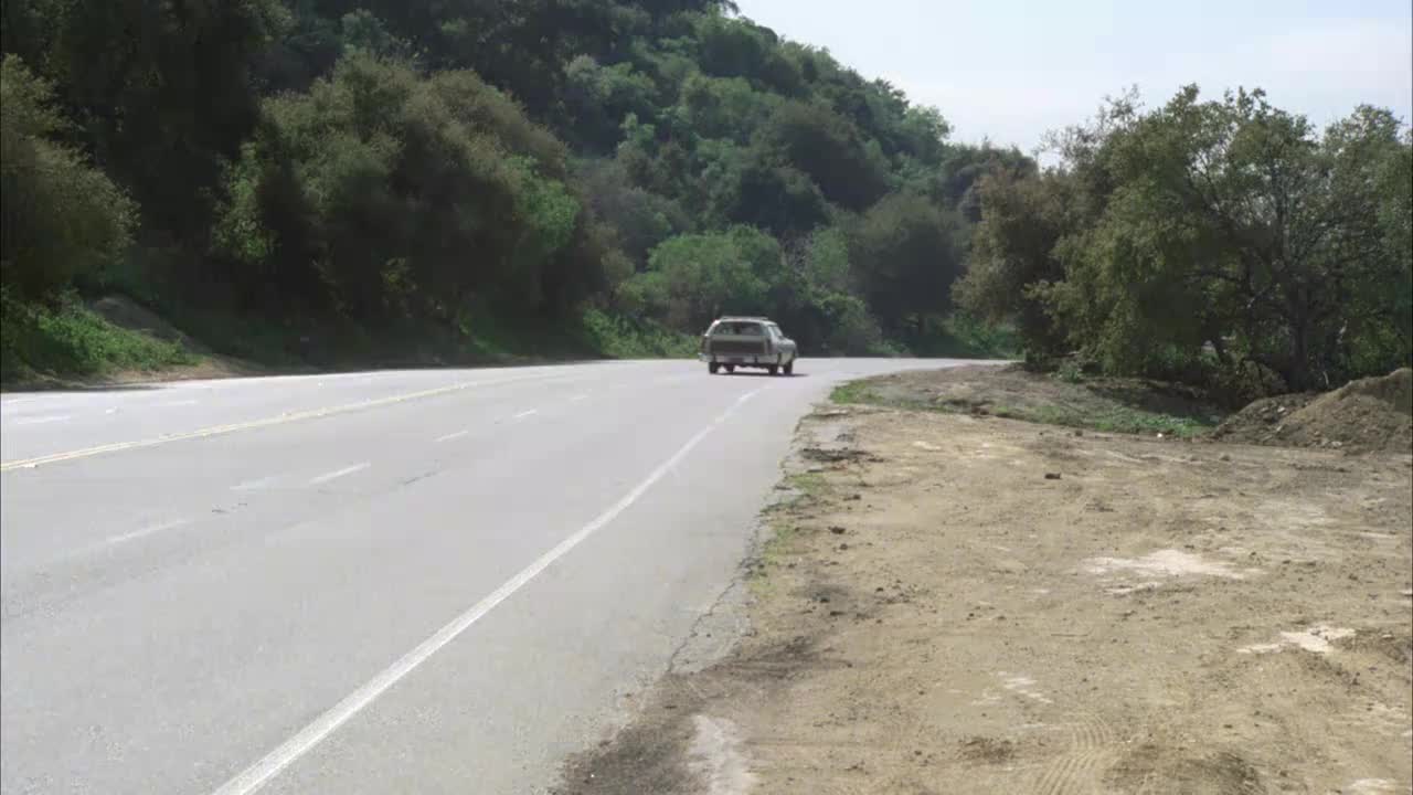 广角车，劳斯莱斯在四车道路上行驶，森林草坪车道。山坡上长满了植物，路的左边有树木。视频素材