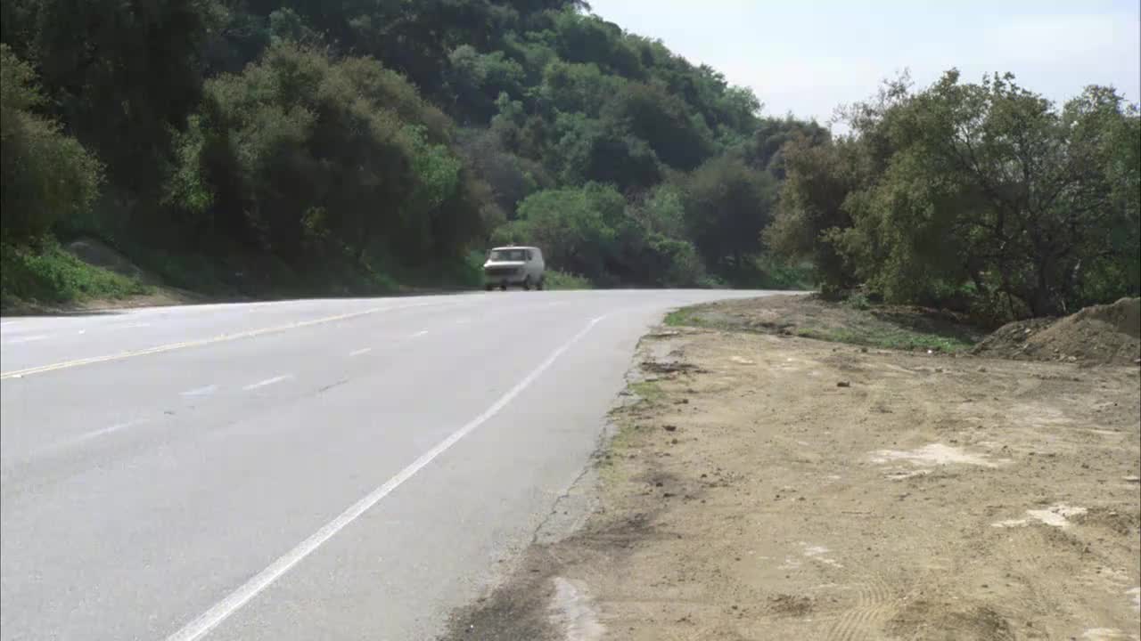 广角车，劳斯莱斯在四车道路上行驶，森林草坪车道。山坡上长满了植物，路的左边有树木。视频素材