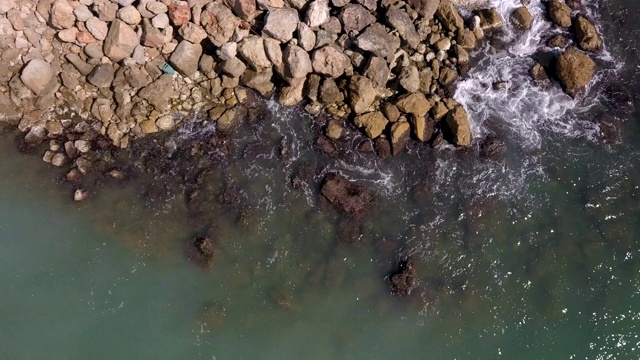 海浪击碎码头岩石的航拍照片视频素材