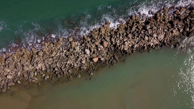 海浪击碎码头岩石的航拍照片视频素材