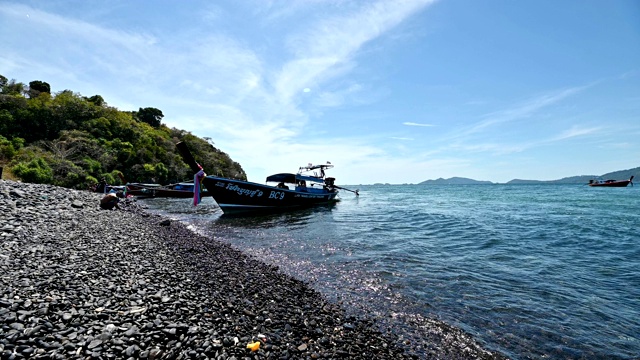 一艘木船停泊在李浦岛的黑石海岸线上视频素材