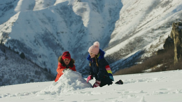 儿童在山/南叉附近堆雪人的慢动作，犹他州，美国视频素材