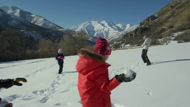 在美国犹他州的山/南福克附近，一家人站在很远的地方打雪仗的慢镜头视频素材