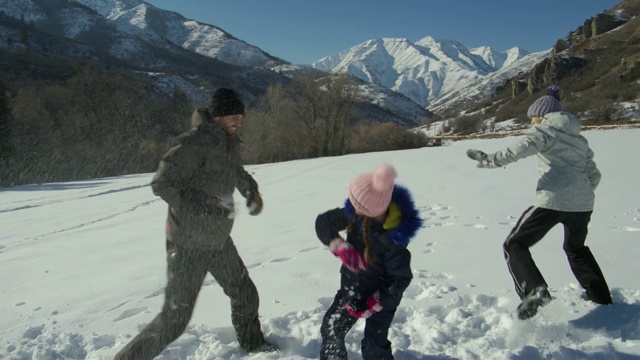 母亲和女儿与男人打雪仗的慢动作附近的山/南叉，美国犹他州视频素材