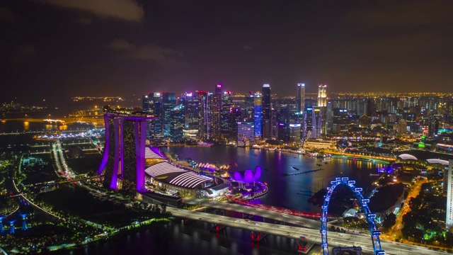 夜间照亮了新加坡城市，飞行在著名的酒店海湾空中全景4k时间延时视频素材