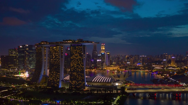 日落之夜照亮新加坡城市飞行滨海湾酒店空中全景4k时间视频素材