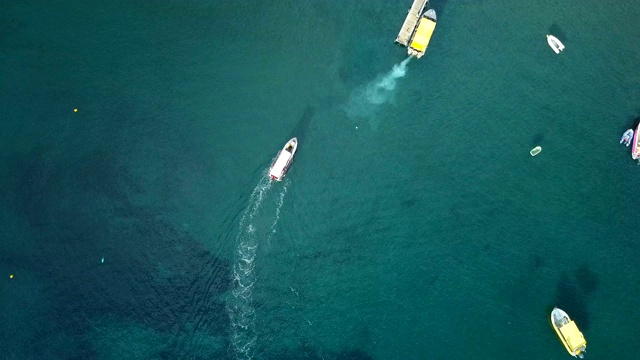 从空中俯瞰瓜德罗普岛加勒比海海湾的一艘浮码头上的船只和帆船。加勒比海蓝色海水的美妙景色。视频素材