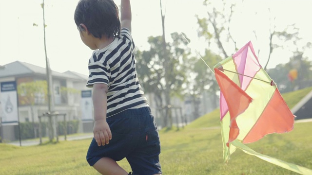 亚洲小男孩跑风筝自由概念夏季自然野外在阳光灿烂的一天。视频素材