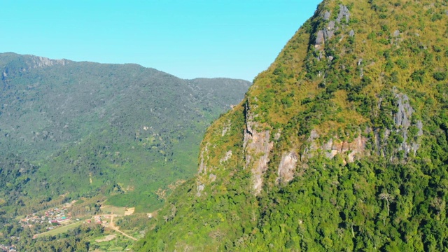 空中:无人机飞越自然热带雨林绿色丛林人口陡峭的山谷悬崖视频素材