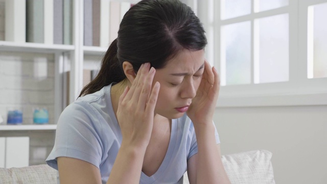 女孩触摸她的太阳穴感到压力。视频素材