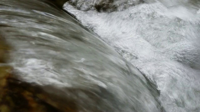 4k特写水从河里的湿岩石倾泻而下视频素材