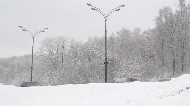 汽车在雪堆后面的冬季城市道路上行驶。第2部分。视频下载