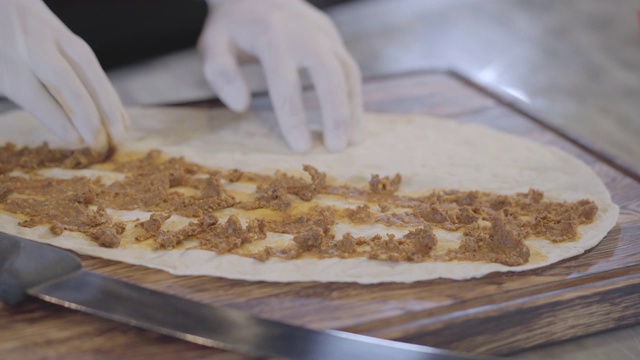 厨师用手小心翼翼地将馅料铺在皮塔饼上。视频素材