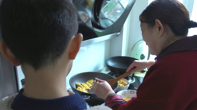 奶奶和孙子煮鸡蛋裹肉视频素材