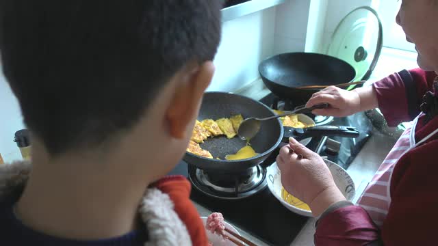 奶奶和孙子煮鸡蛋裹肉视频素材