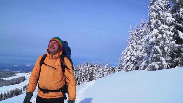 一位游客在山中的雪中行走。视频素材