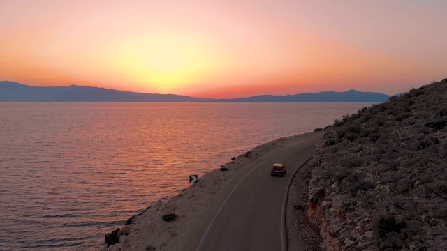 航拍:在令人惊叹的日出中，在一辆黑色SUV后面探索Lefkas。视频素材